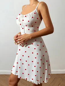 Detail shot of white camisole nightdress with red heart prints and bow tie detail.