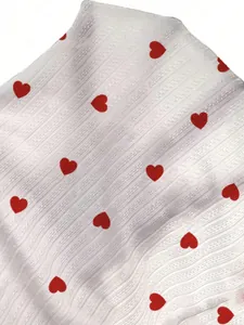 Macro view of white textured lace fabric with romantic red heart patterns for nightwear