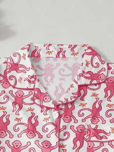 Nahaufnahme des verspielten rosa Affenmusters auf einem weißen Damen-Schlafanzugset