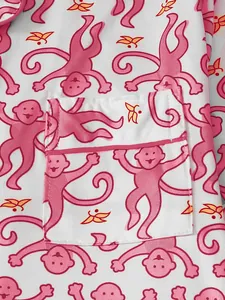 Detailansicht des rosa Affenmusters und der Tasche am Schlafanzugoberteil für Damen.