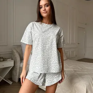 Stylish women's two-piece pajama set featuring grey leopard print in a cozy bedroom setting