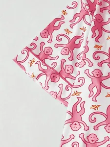 Detailansicht des niedlichen rosa Affen-Prints auf dem weichen weißen Pyjama-Stoff