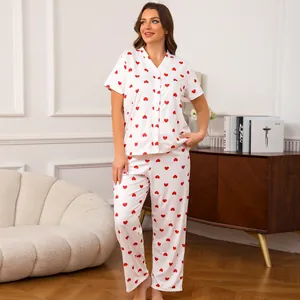 Stijlvolle witte pyjama met knoopjes en rode hartjesprint in een gezellige huiselijke sfeer