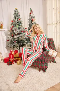Photo d'une femme portant l'ensemble de pyjama de Noël rayé dans un salon festif chaleureux