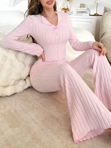 Pyjama rose côtelé à manches longues avec nœud pour femme dans une chambre douillette