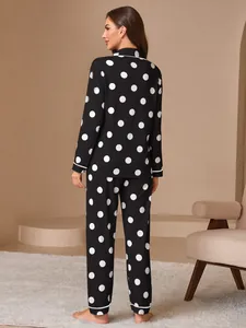 Back view of women's black long sleeve pajama set with large white polka dots