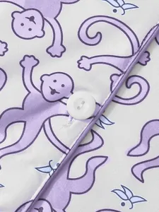 Nahaufnahme des Cartoon-Affen-Prints und des weißen Knopfes auf dem Schlafanzugstoff