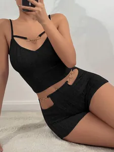 Dettaglio del set da casa in maglia nera con eleganti decorazioni in metallo a cuore