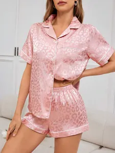 Detailansicht des rosa Satin-Schlafanzug-Sets mit Leopardenmuster und Knopfleiste