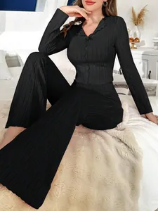 Détail d'un ensemble de détente côtelé noir avec col à nœud et pantalon évasé