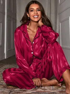 Femme posant dans un pyjama de luxe en satin à rayures bordeaux avec un design à revers