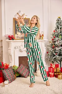 Femme portant un ensemble de pyjama de Noël à rayures vertes dans un décor festif