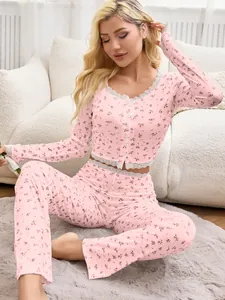 Detailed view of pink floral pajama set with delicate lace trim on hem and cuffs.