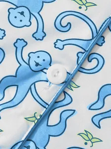 Nahaufnahme des niedlichen blauen Affen-Cartoondrucks auf weißem Pyjama-Stoff mit Knopf