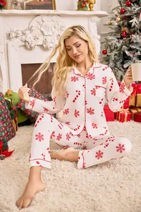 Cozy women's Christmas pajama set featuring red snowflake and candy cane prints on white fabric.