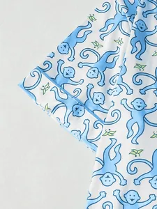 Detailansicht des süßen blauen Affenmusters auf dem weißen Stoff des Pyjama-Ärmels