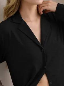 Detailaufnahme des schwarzen langärmeligen Damen-Schlafanzugs mit Reverskragen.