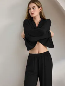 Elegantes schwarzes langärmliges Schlafanzug-Set mit Hose auf einem Model gezeigt
