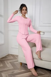 Detailed view of a pink ribbed long-sleeve loungewear set worn by a model in a room.