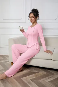 Full-length detail of a woman wearing a pink ribbed long-sleeve pajama set indoors