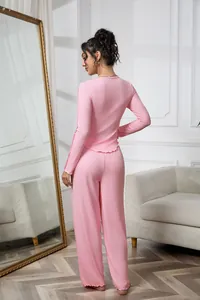 Back view of woman wearing a pink ribbed long-sleeve loungewear set in a bright room