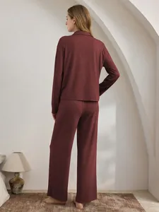 Rückansicht eines weinroten Damen-Schlafanzug-Sets in einem gemütlichen Interieur