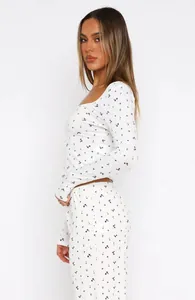 Side view of white floral loungewear set featuring long sleeves and high waist pants