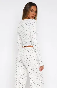 Back view of a women's white floral pajama set with long sleeve crop top and pants.