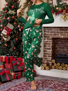 Women's green Christmas pajama set with Santa and tree prints in festive home setting.