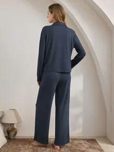Rückansicht eines bequemen anthrazitblauen zweiteiligen Pyjama-Sets für Damen im Zimmer
