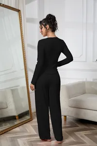 Back view of elegant black ribbed long sleeve top and pants lounge set in a bedroom setting