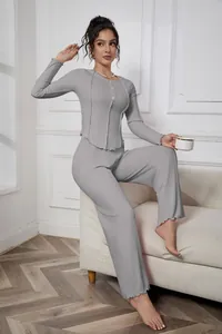Full-body view of a model in a grey ribbed knit loungewear set posing in a living room
