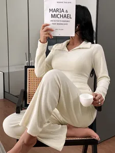 Close-up of a model wearing a cream knitted polo loungewear set sitting on a wicker chair