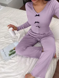Detail of lavender pajama set with decorative black bows and ruffled edges