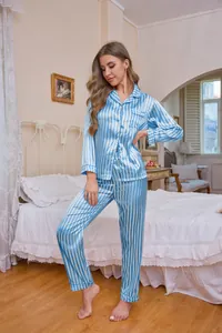 Detailed lifestyle view of women's blue and white striped satin pajama set in a bedroom
