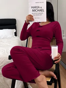 Detail of slim-fit burgundy thermal pajamas with bow accents in a bedroom setting