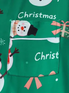 Gros plan d'une poche de pyjama de Noël vert avec motifs de bonhomme de neige et cadeaux.