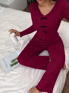 Close-up of maroon long-sleeve pajama set with black bow details and ruffled hems