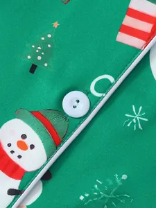 Détail rapproché du pyjama de Noël vert avec imprimé bonhomme de neige et bouton blanc