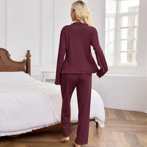 Women's two-piece maroon pajama set with textured fabric, long sleeves and pants in bedroom