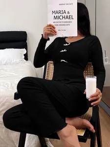 Detailed shot of a women's black slim fit pajama set featuring three small pink bow accents
