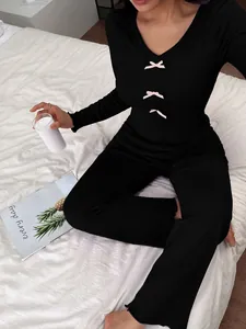 Detailed view of women's black slim fit loungewear set featuring cute pink bows and ruffled edges