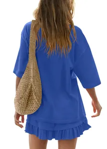 Back view of woman in blue short sleeve t-shirt and ruffled mini skirt set with bag