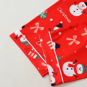 Détail du pyjama de Noël rouge avec imprimés bonshommes de neige et finitions blanches.