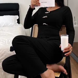Stylish women's black velvet pajama set featuring pink bow details and a slim fit cut