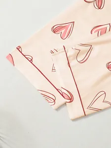 Detail view of the soft fabric and pink heart print pattern on pajama set trouser cuff