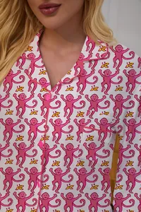 Close-up of women's pajama top featuring playful pink monkey and yellow banana patterns