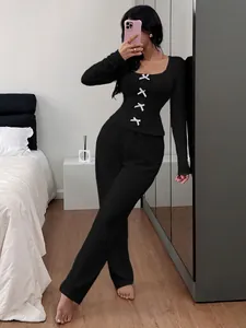 Detail of women's black ribbed knit loungewear set with decorative bows on the top.