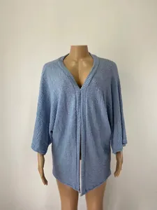 Détail de la maille gaufrée bleue sur un cardigan ample à manches 3/4