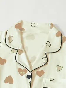 Close-up of heart print pajama top featuring elegant lapel collar and smooth satin finish